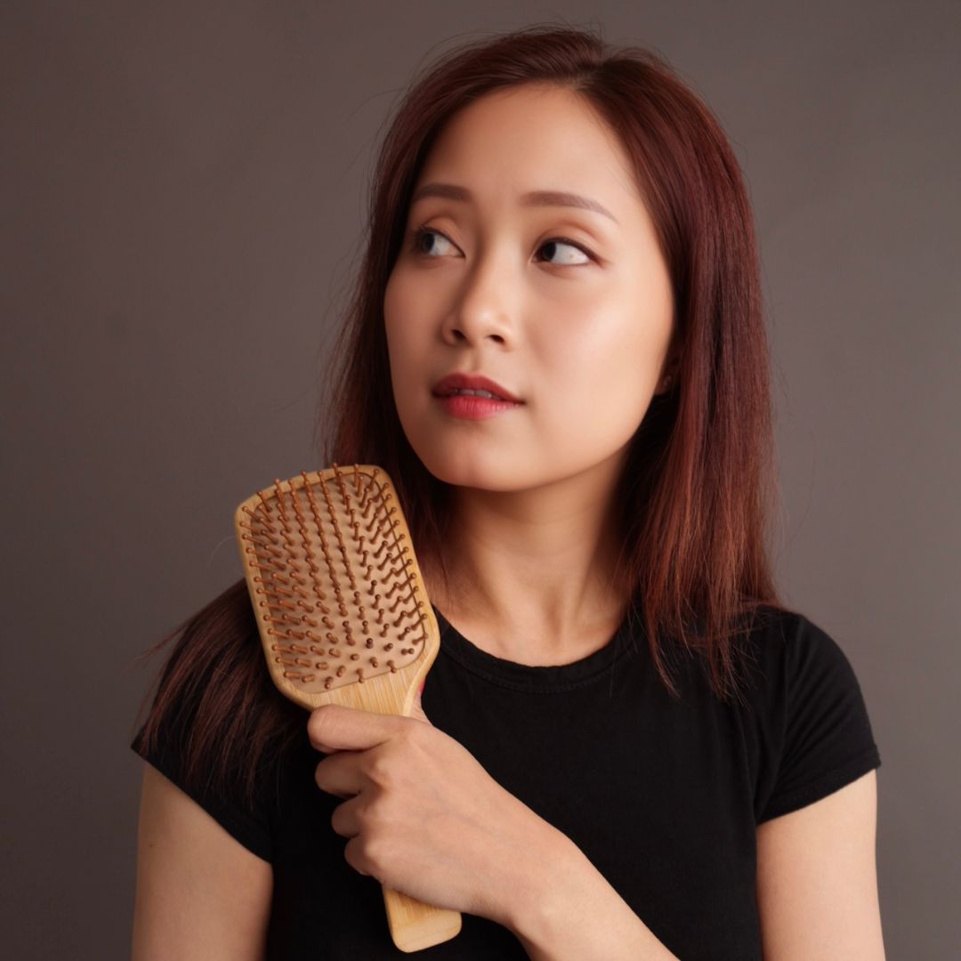 Woman holding a Natural Bamboo Hair Brush