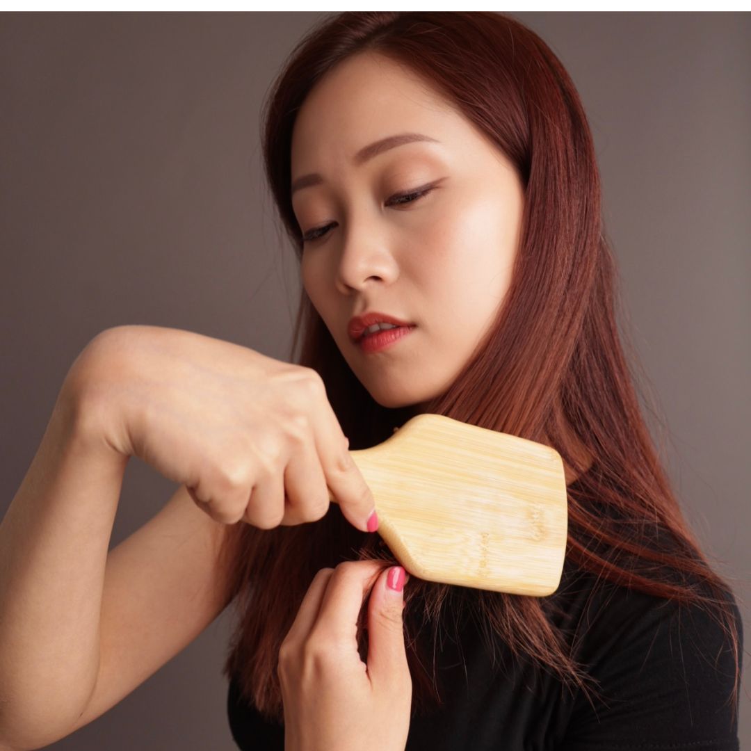 Woman brushing her hair smoothly with Miriam's Natural Bamboo Brush