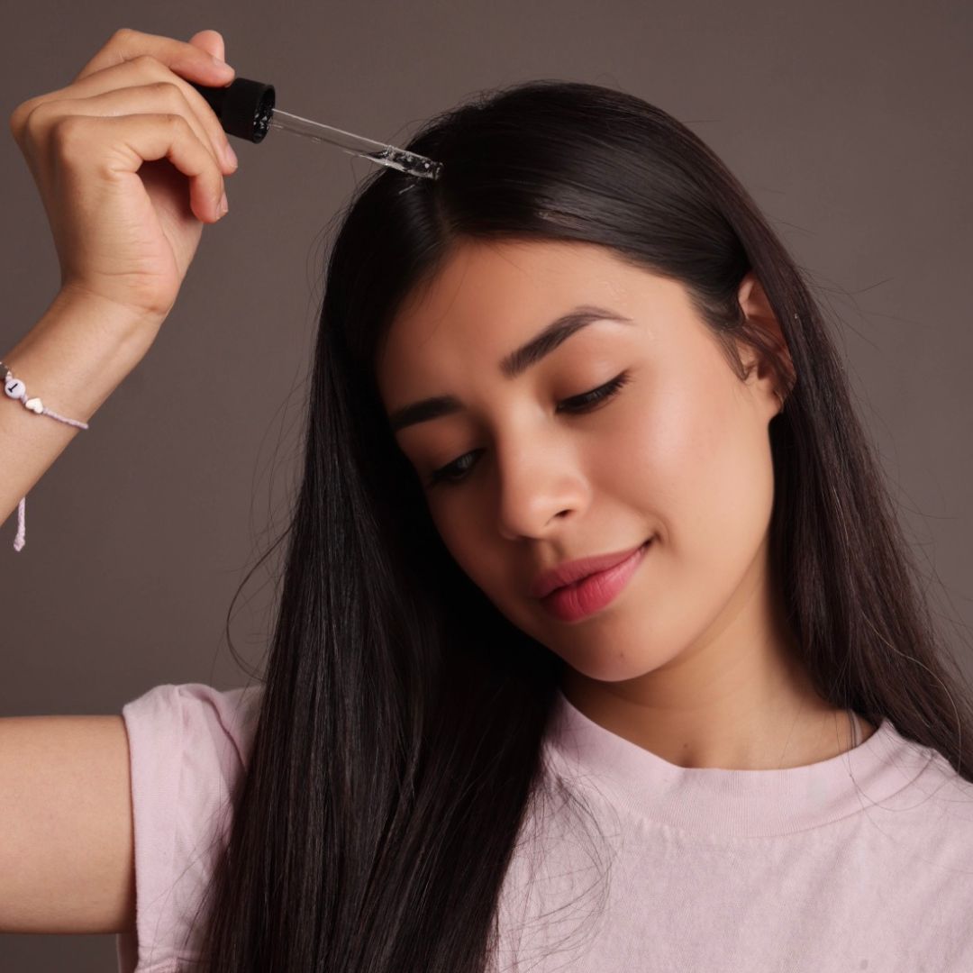 Woman applying Miriam's 18 Oil Blend Hair Growth Oil  On her Shiny and smooth hair